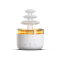 Humidificateur nuage de pluie coloris blanc sur fond blanc, bassin illuminé en ambré et trois plateaux superposés