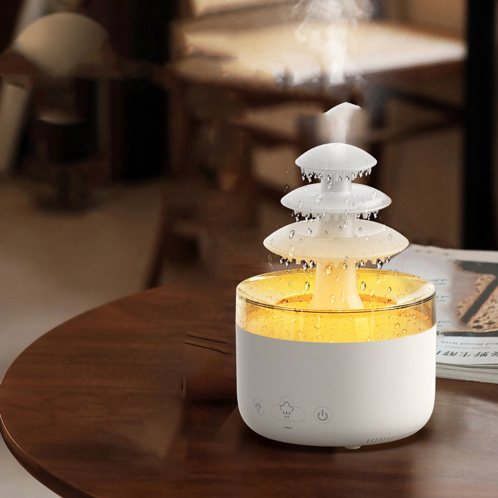 Humidificateur nuage de pluie en lumière ambrée sur une table ronde en bois foncé